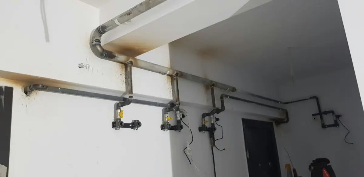 Țevi de instalație de gaz montate pe un perete, cu robineți